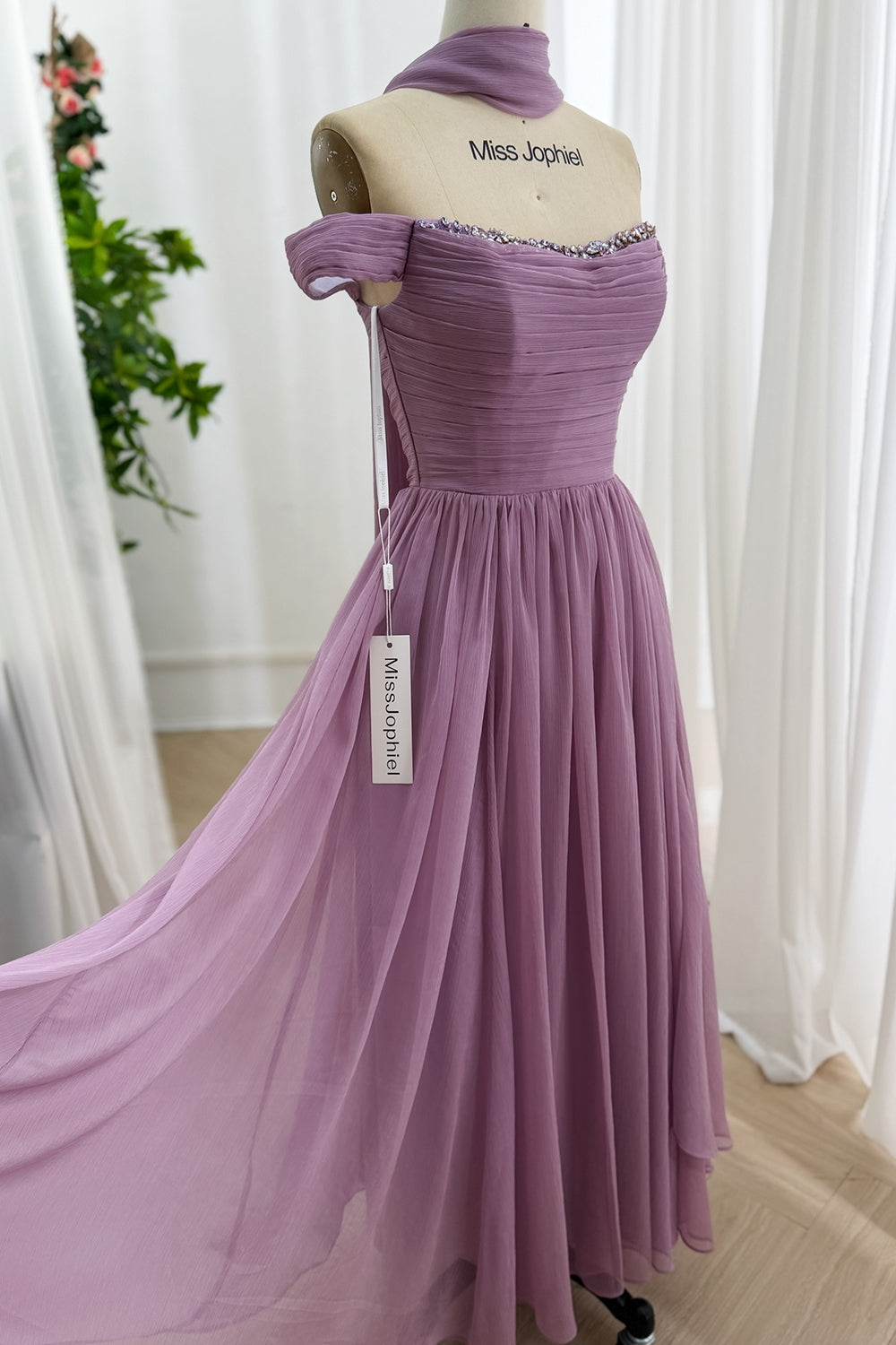 Mauve purple floorlength dress shows gathered waist, airy skirt, crystal neckline, boutique studio presentation