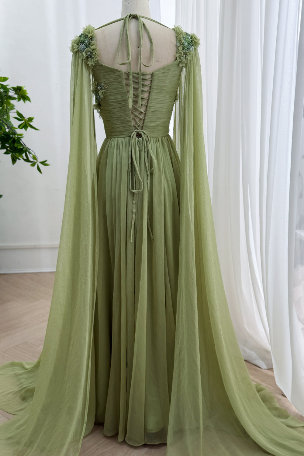 Rear silhouette presents adjustable closure, sweeping panels, soft train, delicate embroidery, enchanted ballroom presence