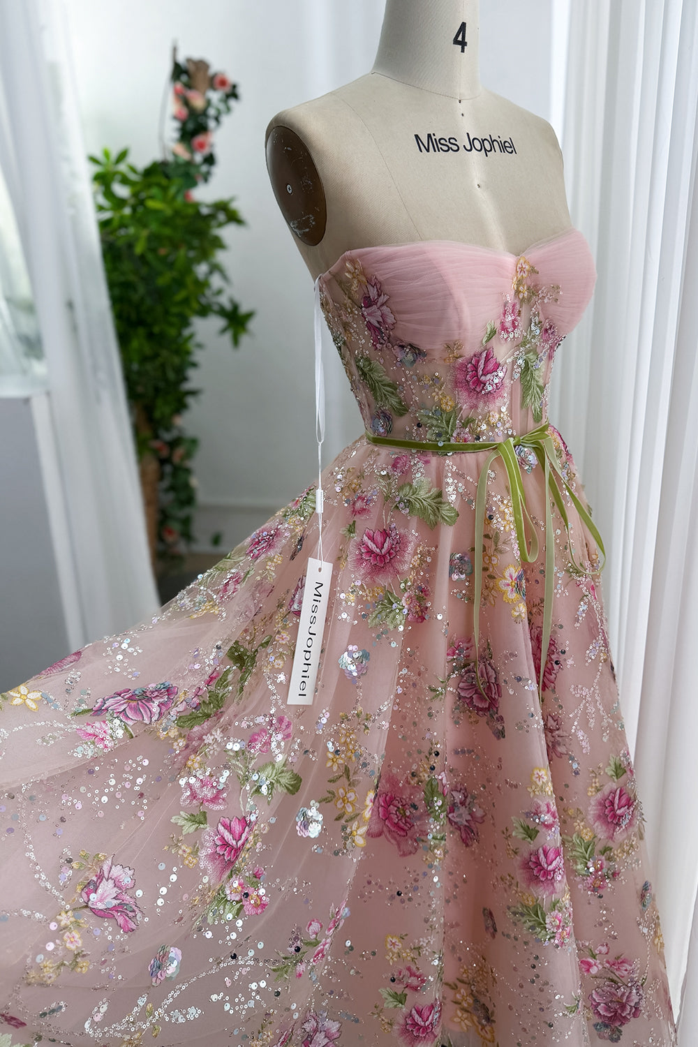 Angled studio image highlights sparkle leafy appliques over full skirt, fairytale formal look with airy movement. opulent joy