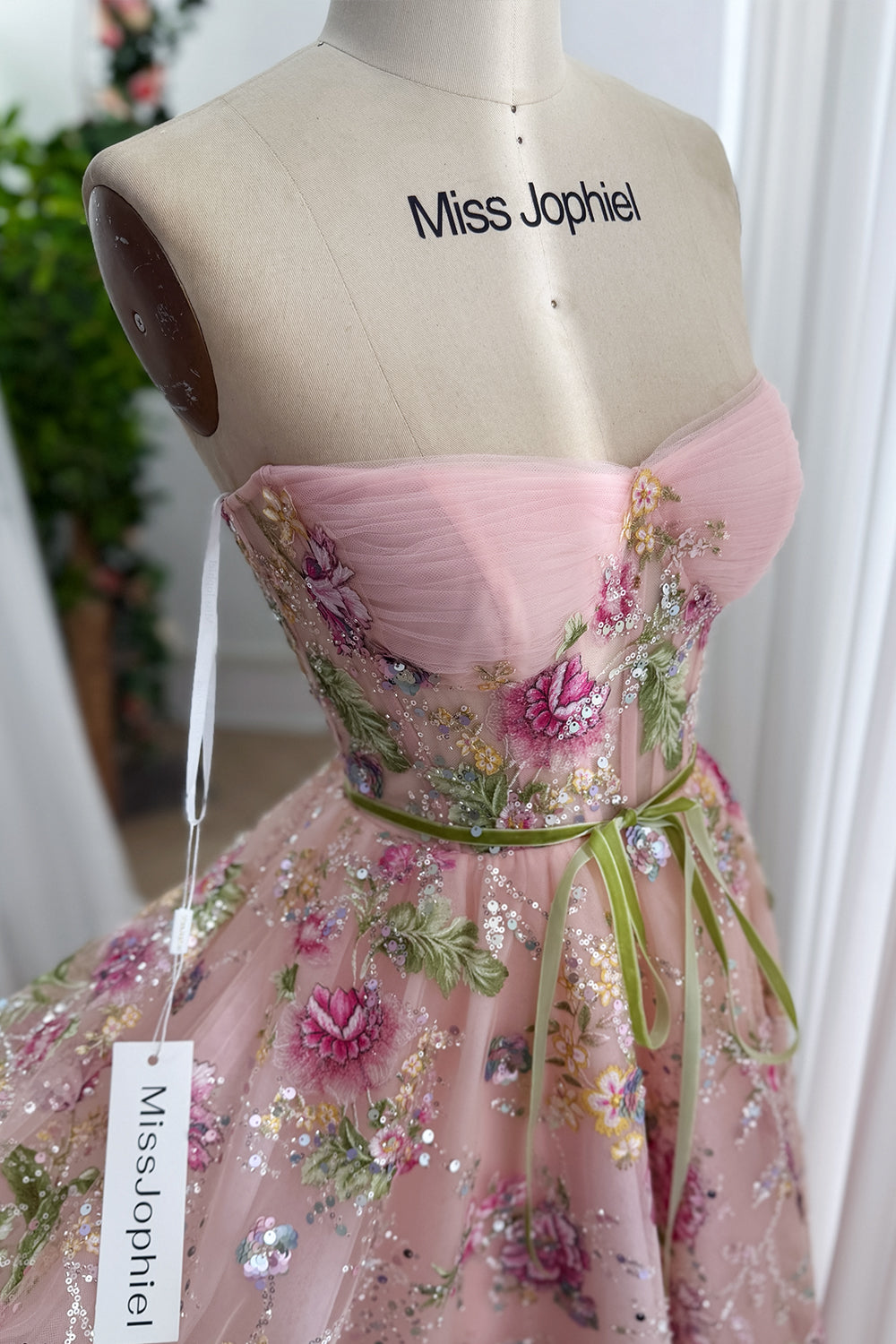 Blush strapless floral sequin tulle gown on mannequin showcasing ruched sweetheart corset bodice for garden prom styling glow