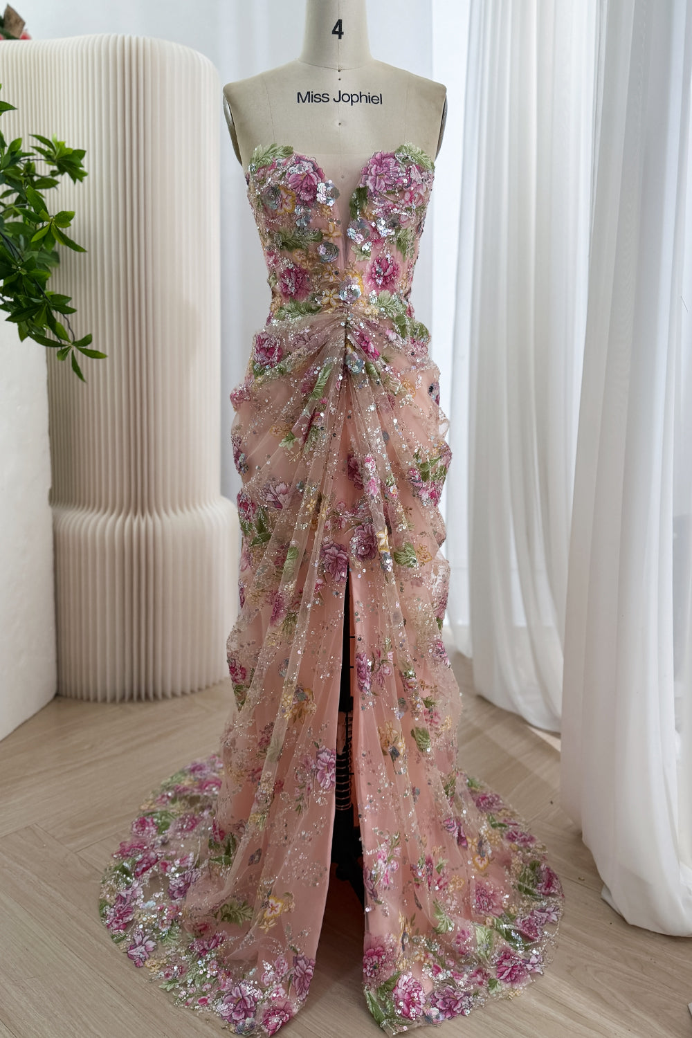 Full front view blush garden bridal column featuring draped tulle overskirt, high slit, botanical appliques, sweep train set.