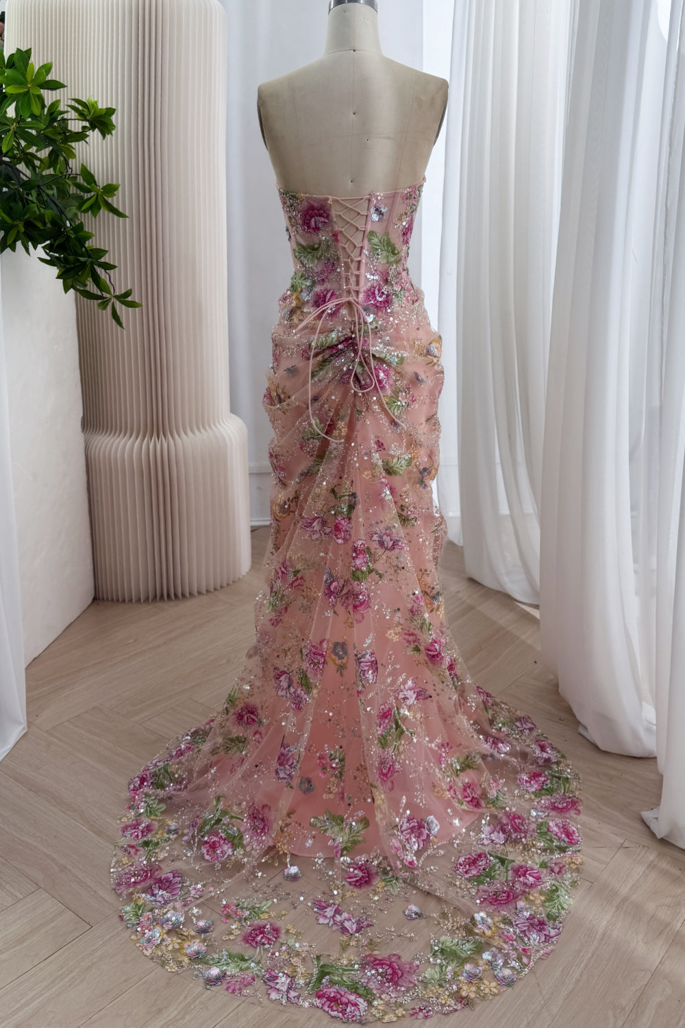 Rear perspective rose embroidered mermaid silhouette with corsetback, fitted waist, cascading sparkle mesh chapel display 3D.