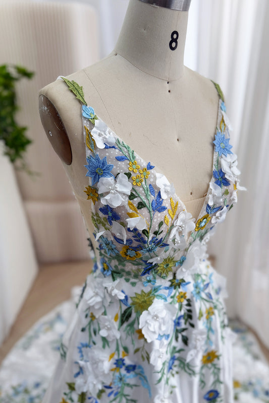 Closeup reveals illusion bodice adorned with pearl-centered blossoms, verdant stitching, fine mesh, romantic couture artistry