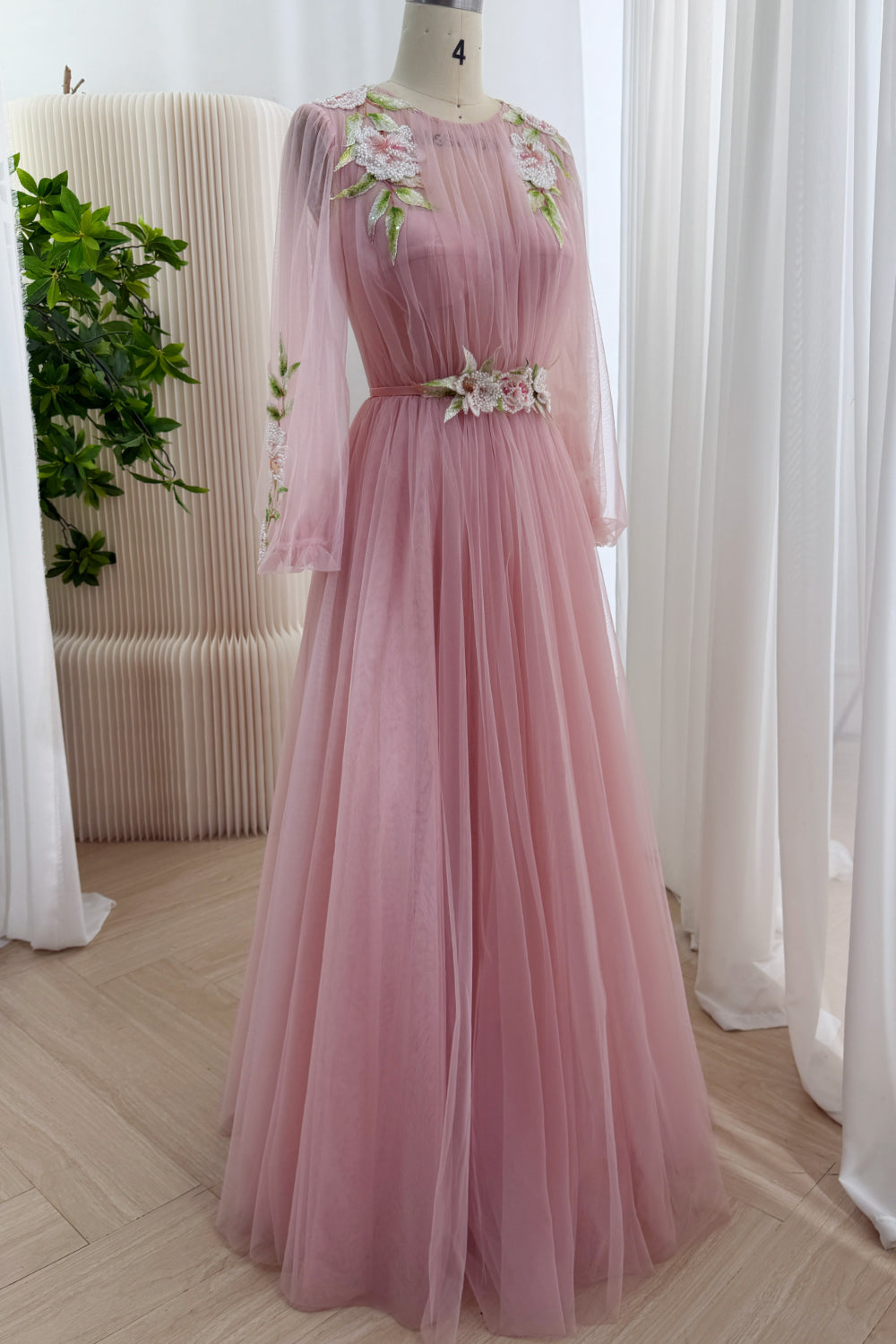 Three-quarter view showcases pink mesh overlay, jewel neckline, vine shoulder embroidery, graceful draping, sweeping hemline.