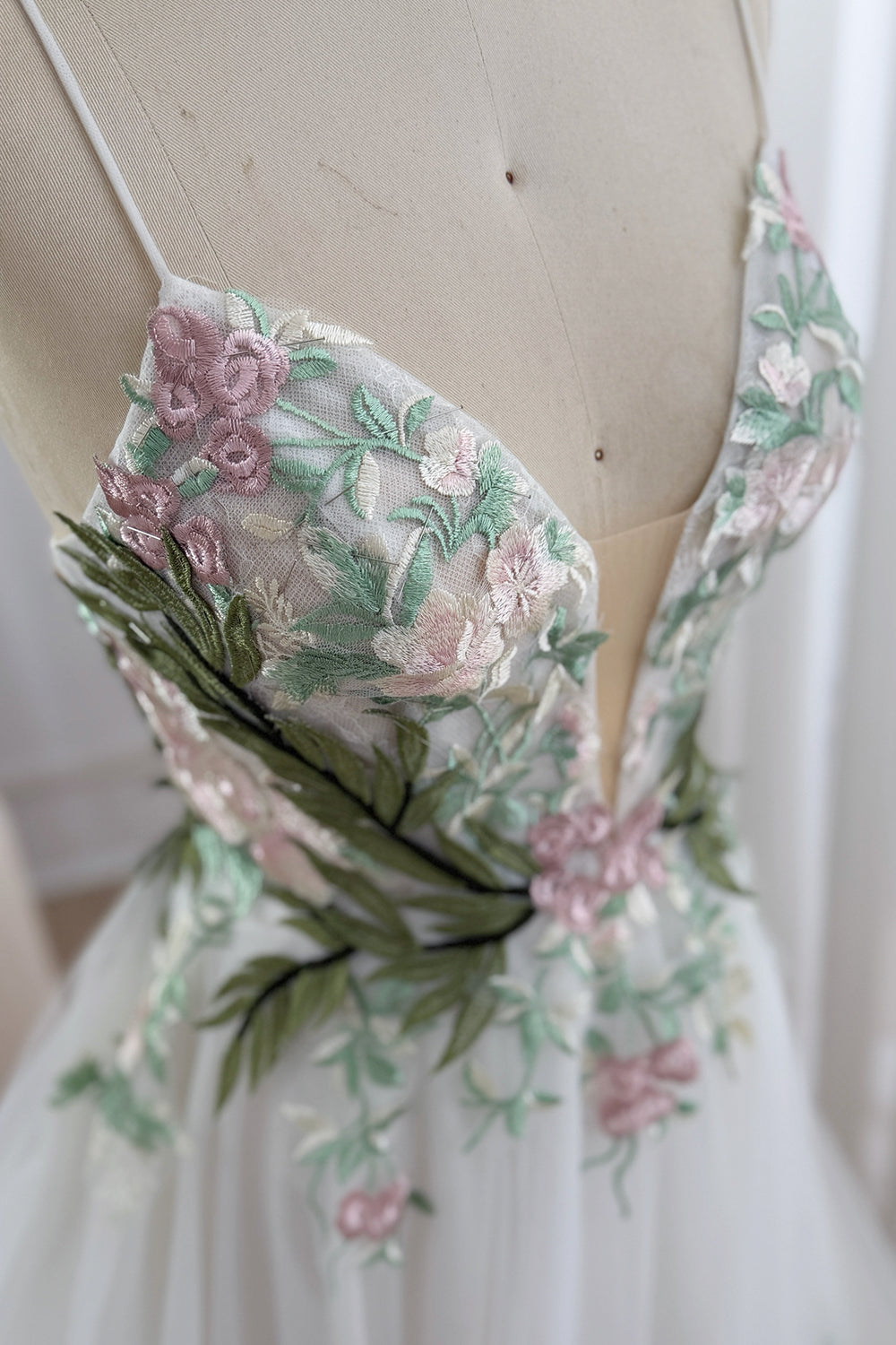 Closeup captures sheer bust paneling, delicate mauve florals, mint vines, olive branches, romantic couture fine craftsmanship
