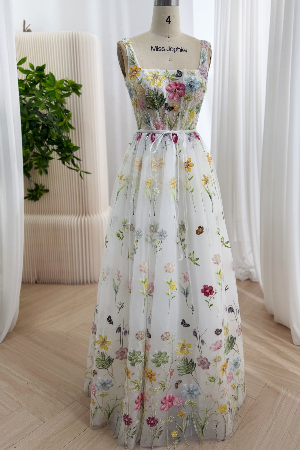 Frontal view presents whimsical wildflower A-line gown featuring square neckline, slender straps, light floor-sweeping skirt.