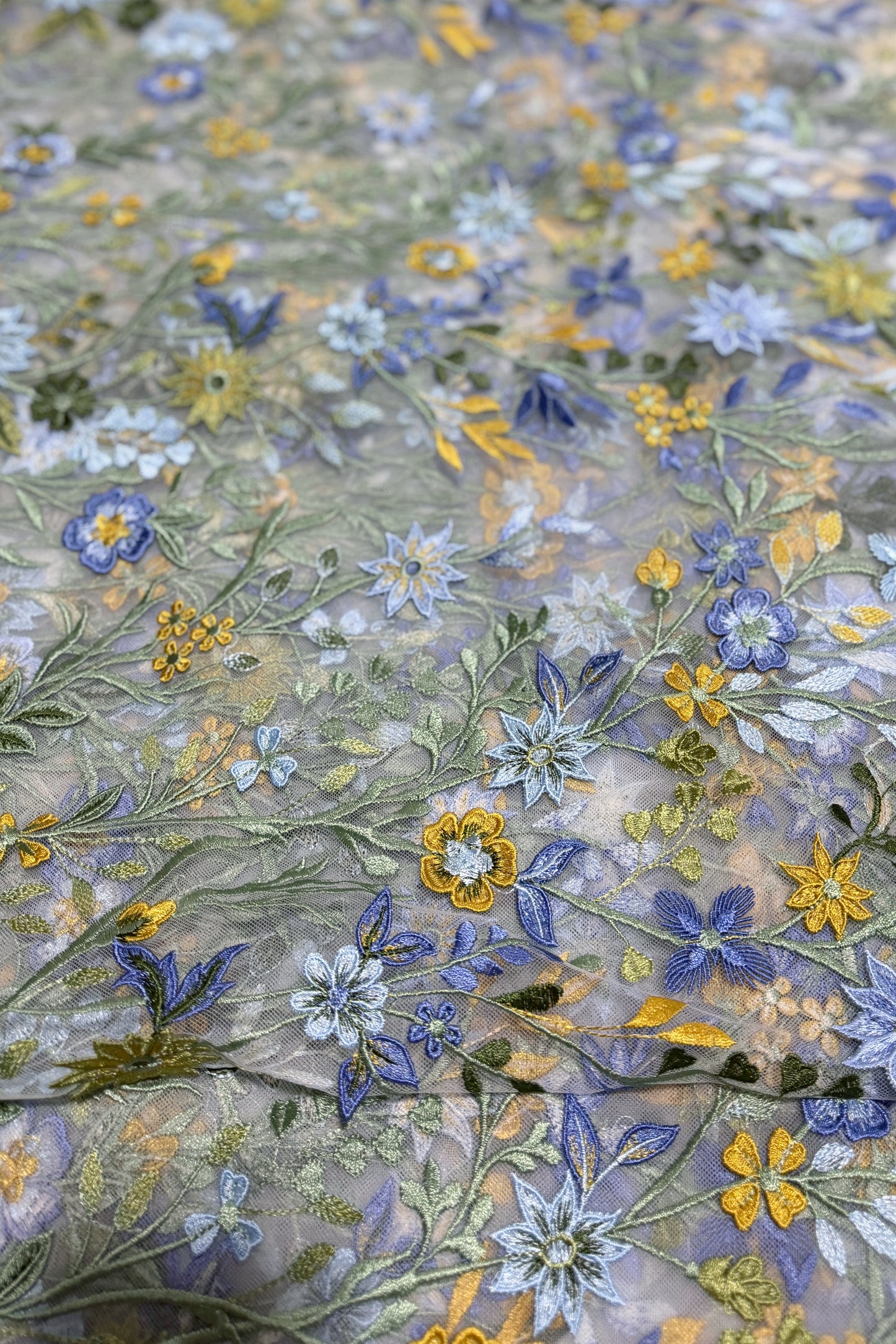 Bestickter Stoff mit Blumenapplikation – weißer Tüll mit mehrfarbigen Blumendetails