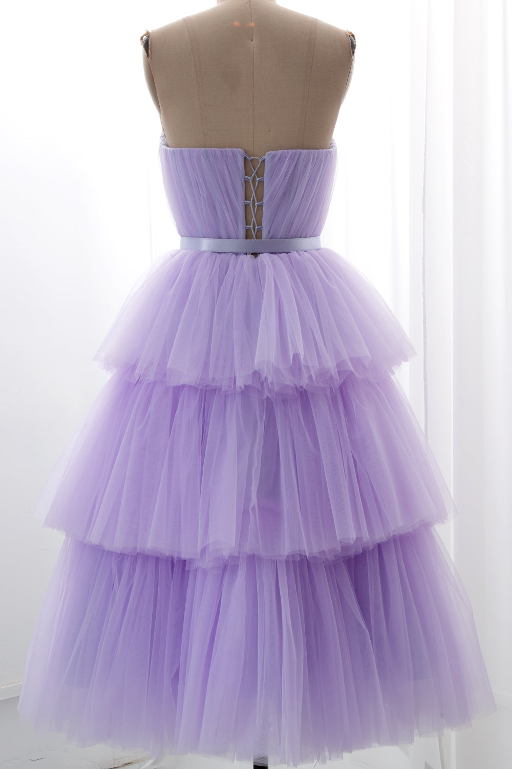 Romantic layered lilac gown featuring ruffled tulle and structured bodice ideal for galas and photo sessions