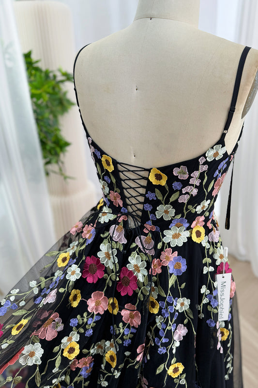 Close-up of the lace-up corset back on a black tulle dress with floral embroidery.
