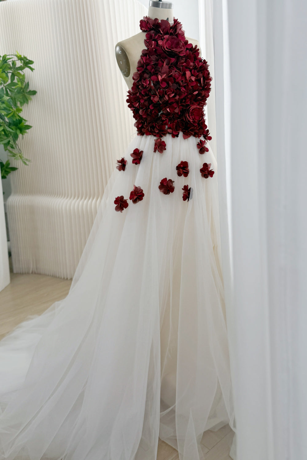 Side view of ivory tulle ball gown with scattered burgundy flowers