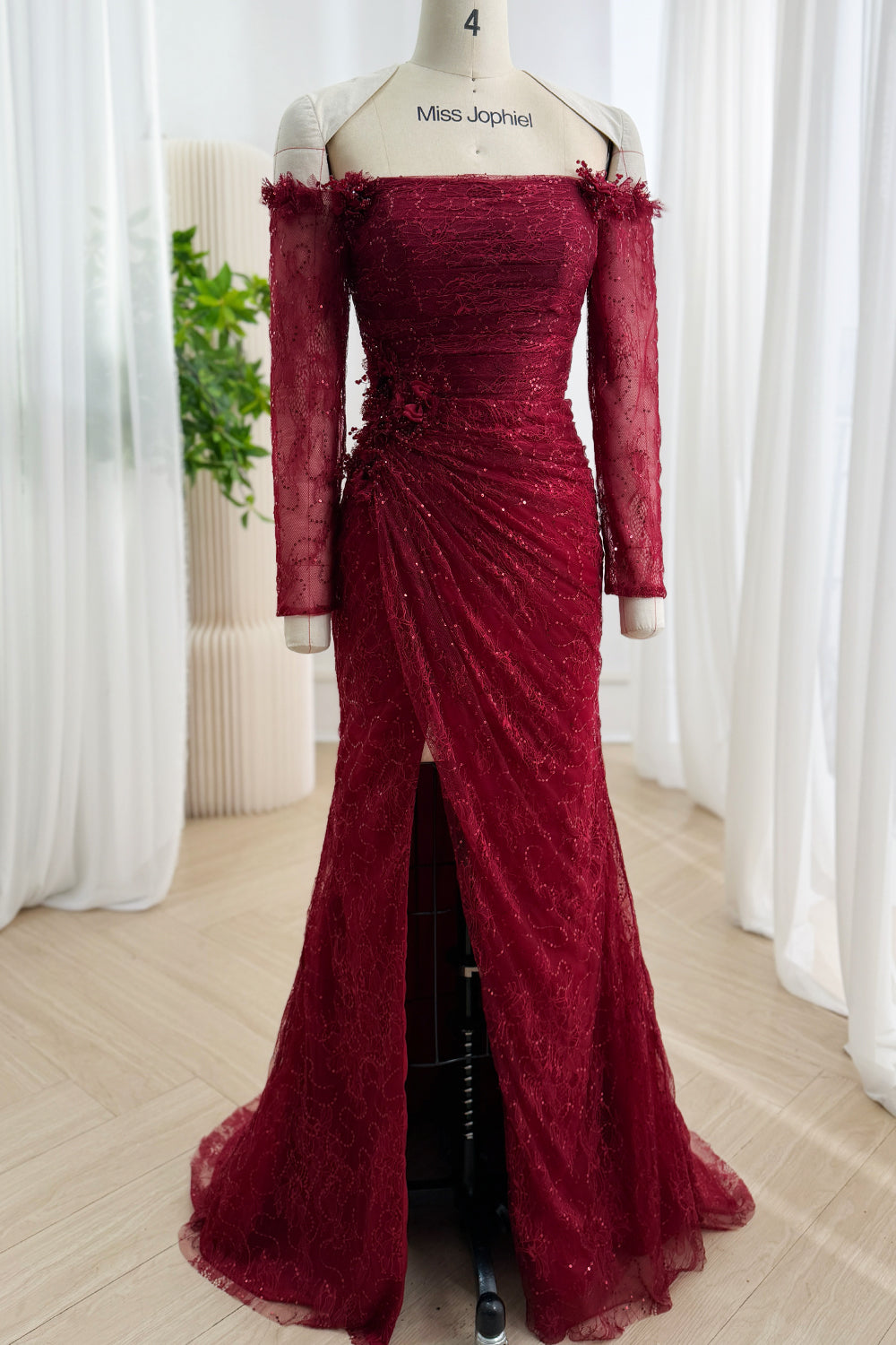 Front view of burgundy off-the-shoulder sequin lace mermaid gown with sheer long sleeves and front slit