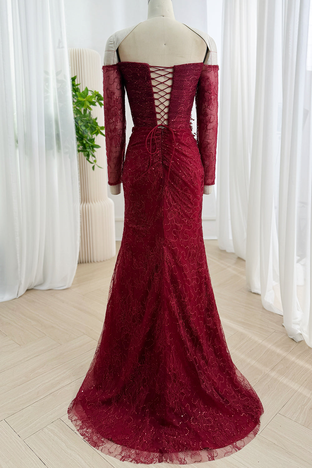 Back view of burgundy sequin lace evening gown with open lace-up back and sweep train