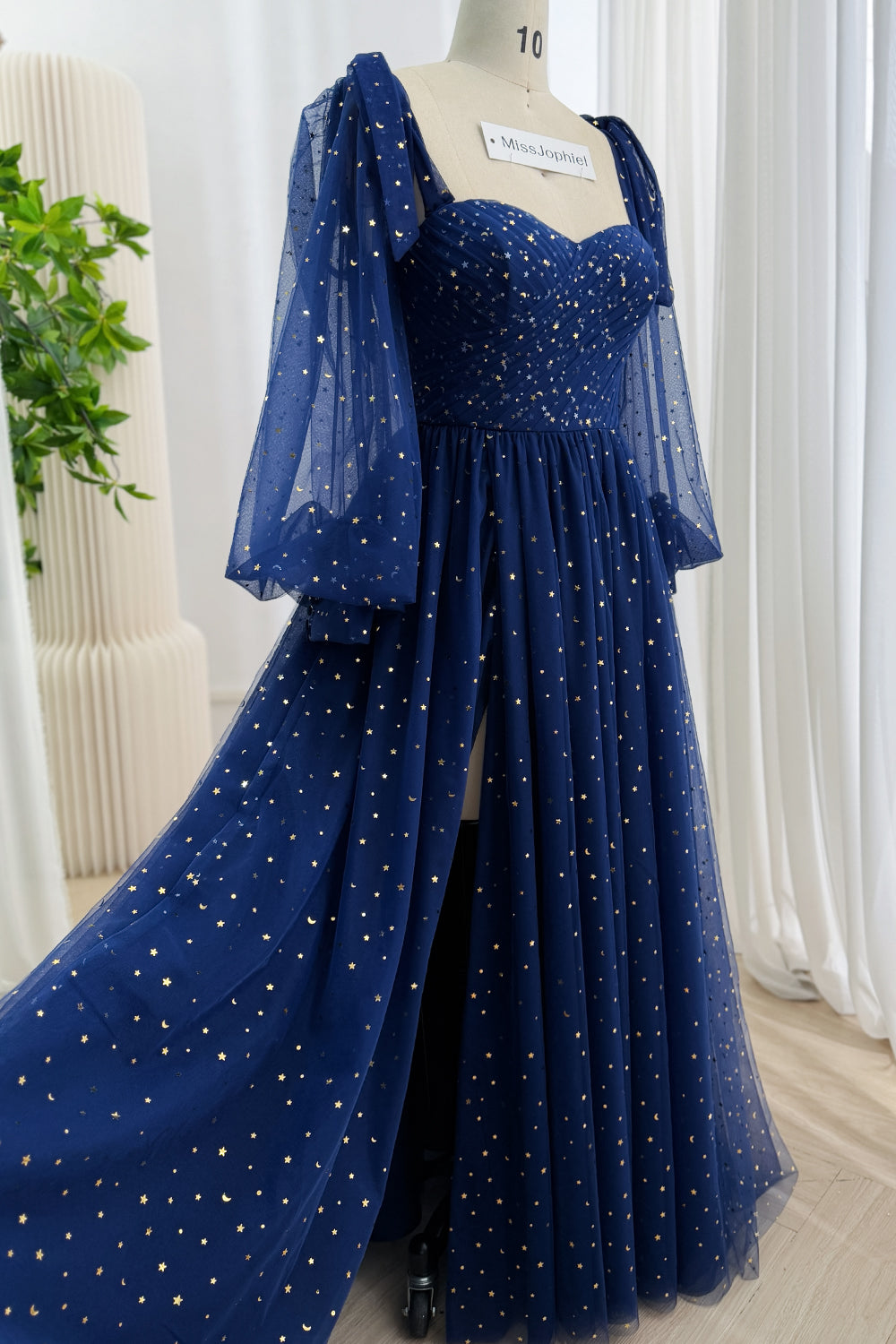 Side view of a floor-length dark navy celestial A-line gown with long sheer flared sleeves