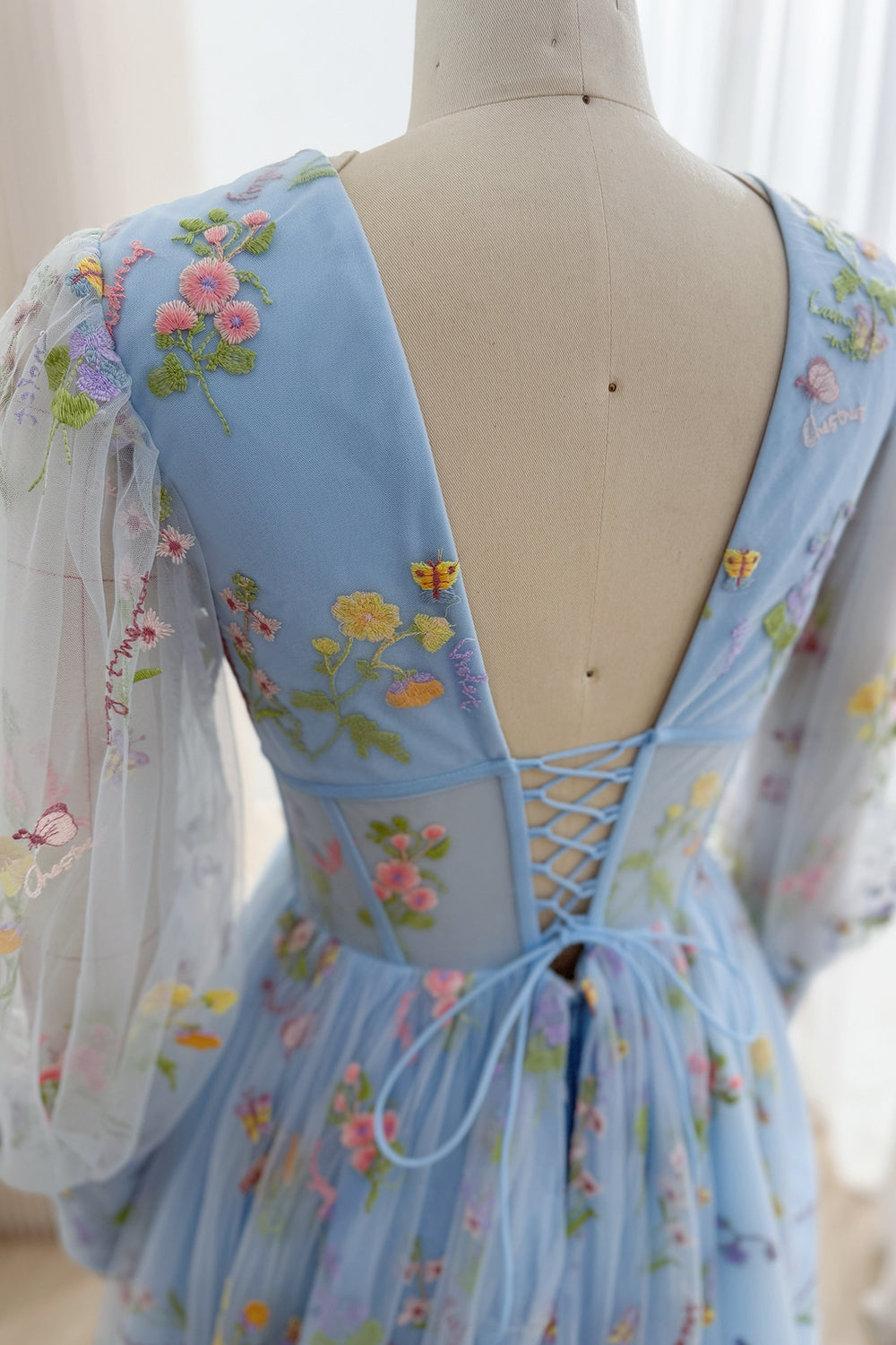 Close-up of the gown's lace-up back and floral embroidered tulle sleeve