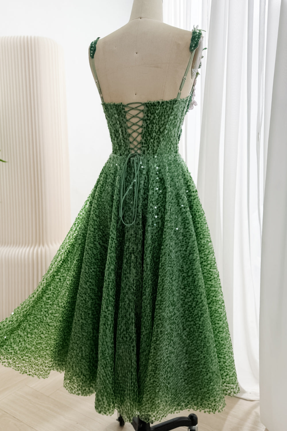 Back view of full green sequin A-line skirt and lace-up bodice