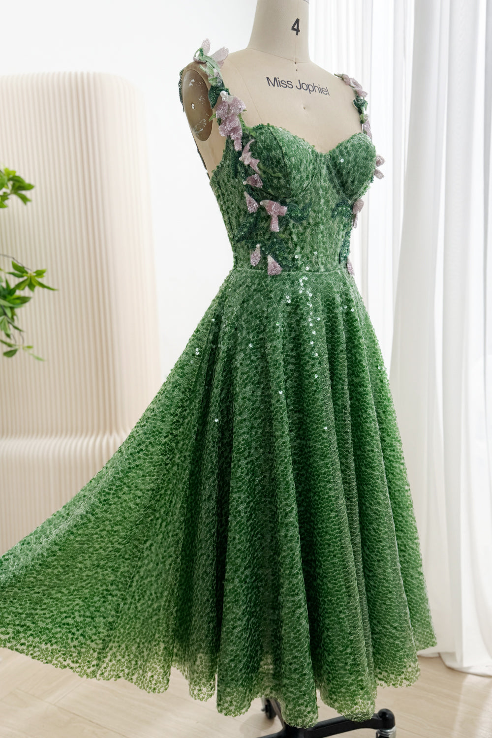 Three-quarter front view of green sequin A-line gown with pink floral bodice