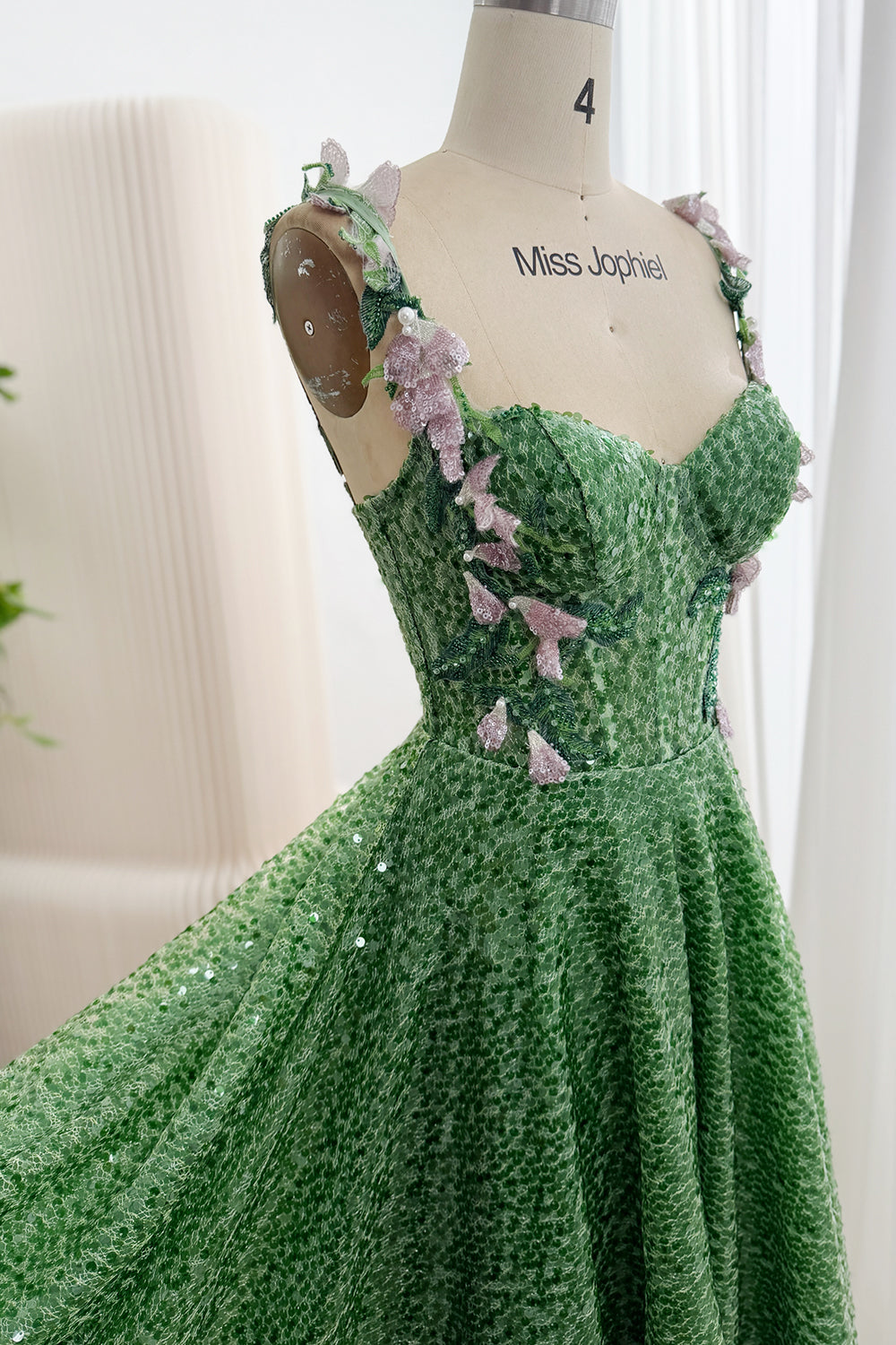 Front detail of green sequin gown with sweetheart bodice and pink floral appliqués