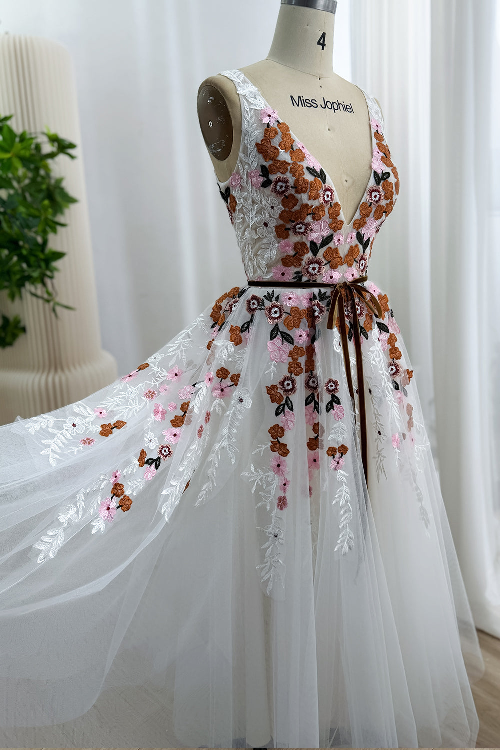 Side view of the ivory embroidered tulle dress showing the fitted V-neck bodice and full A-line skirt