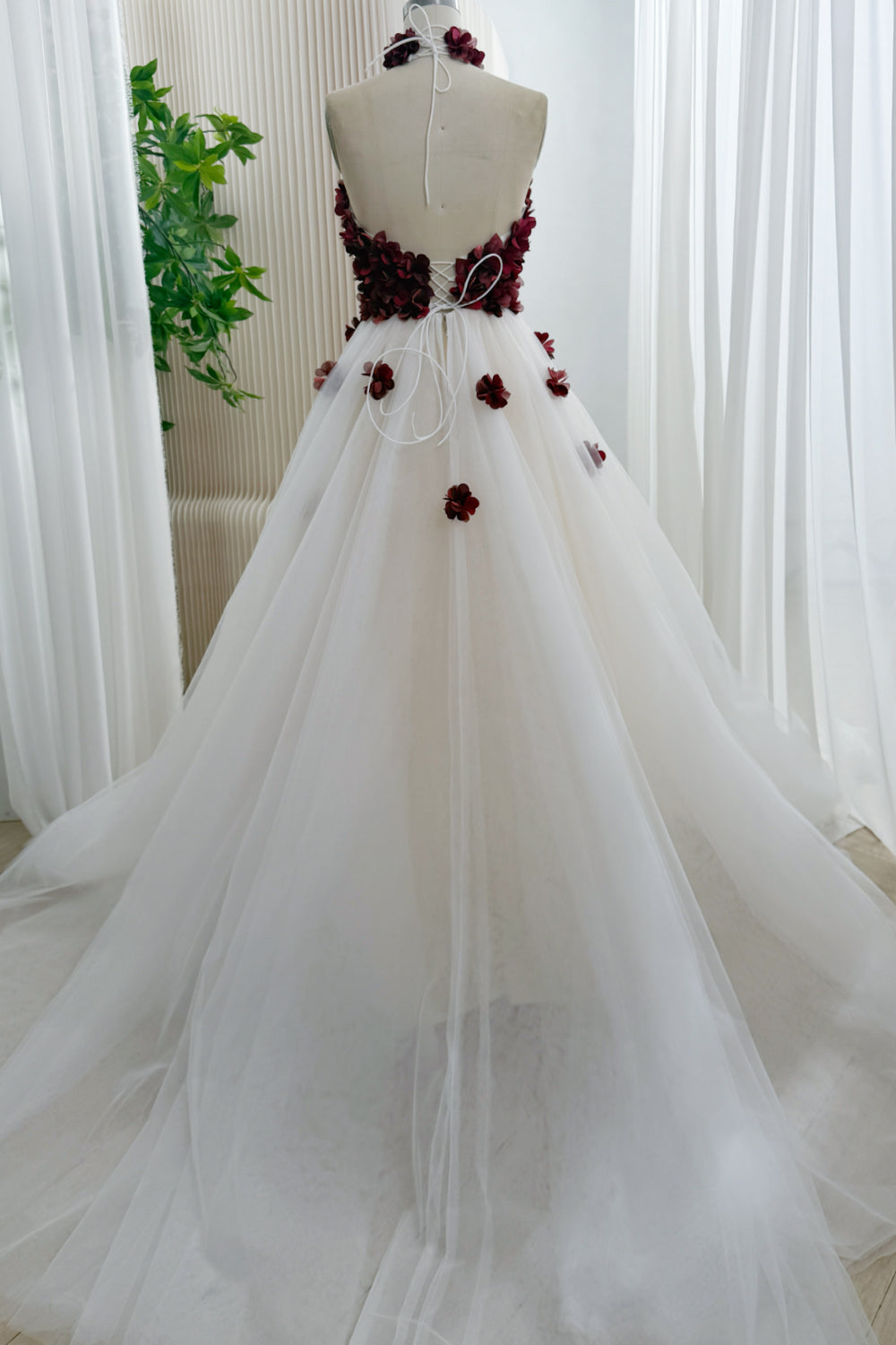 Back view of ivory tulle ball gown with burgundy floral bodice