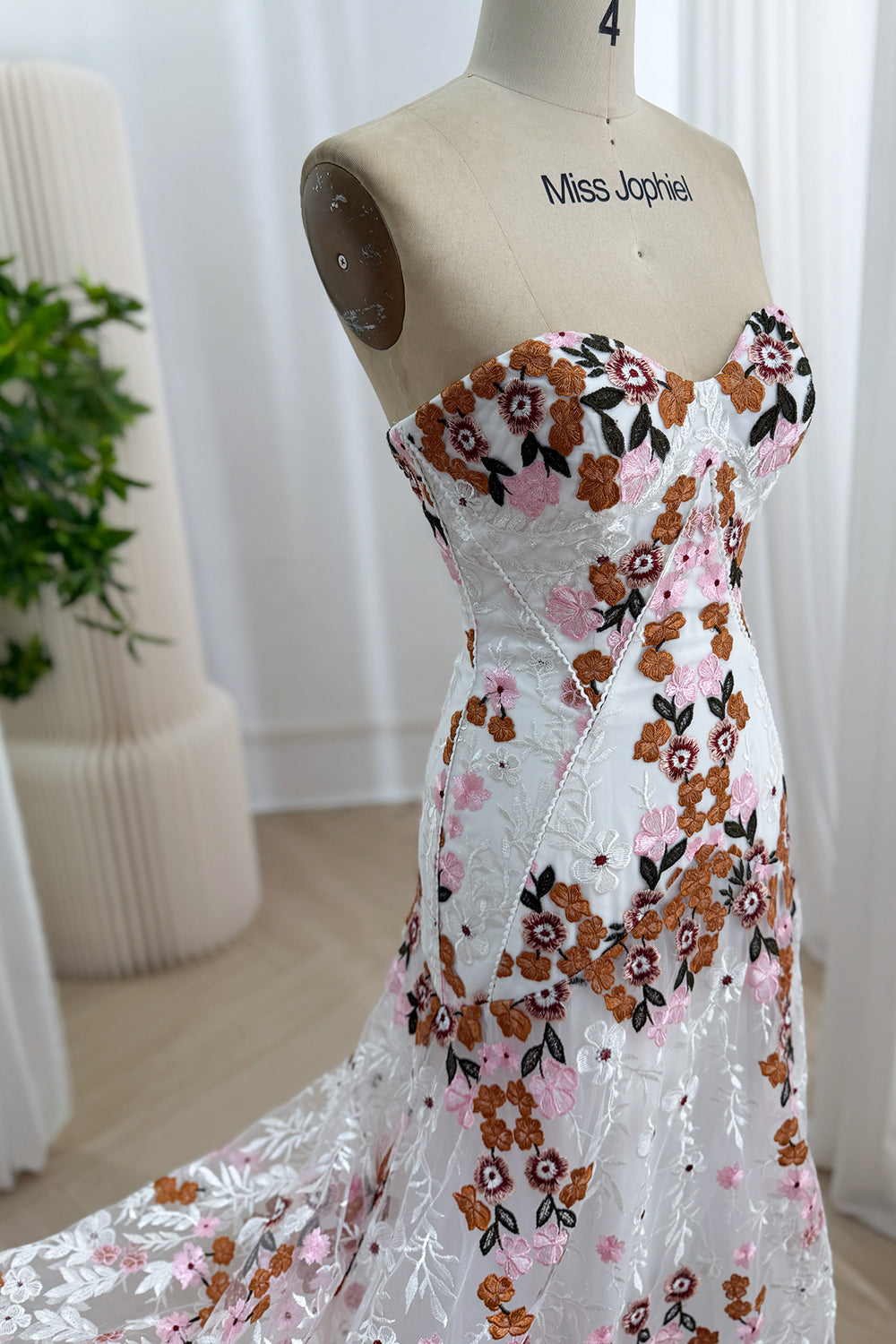 Close-up side view of the fitted sweetheart bodice and multicolor floral embroidery