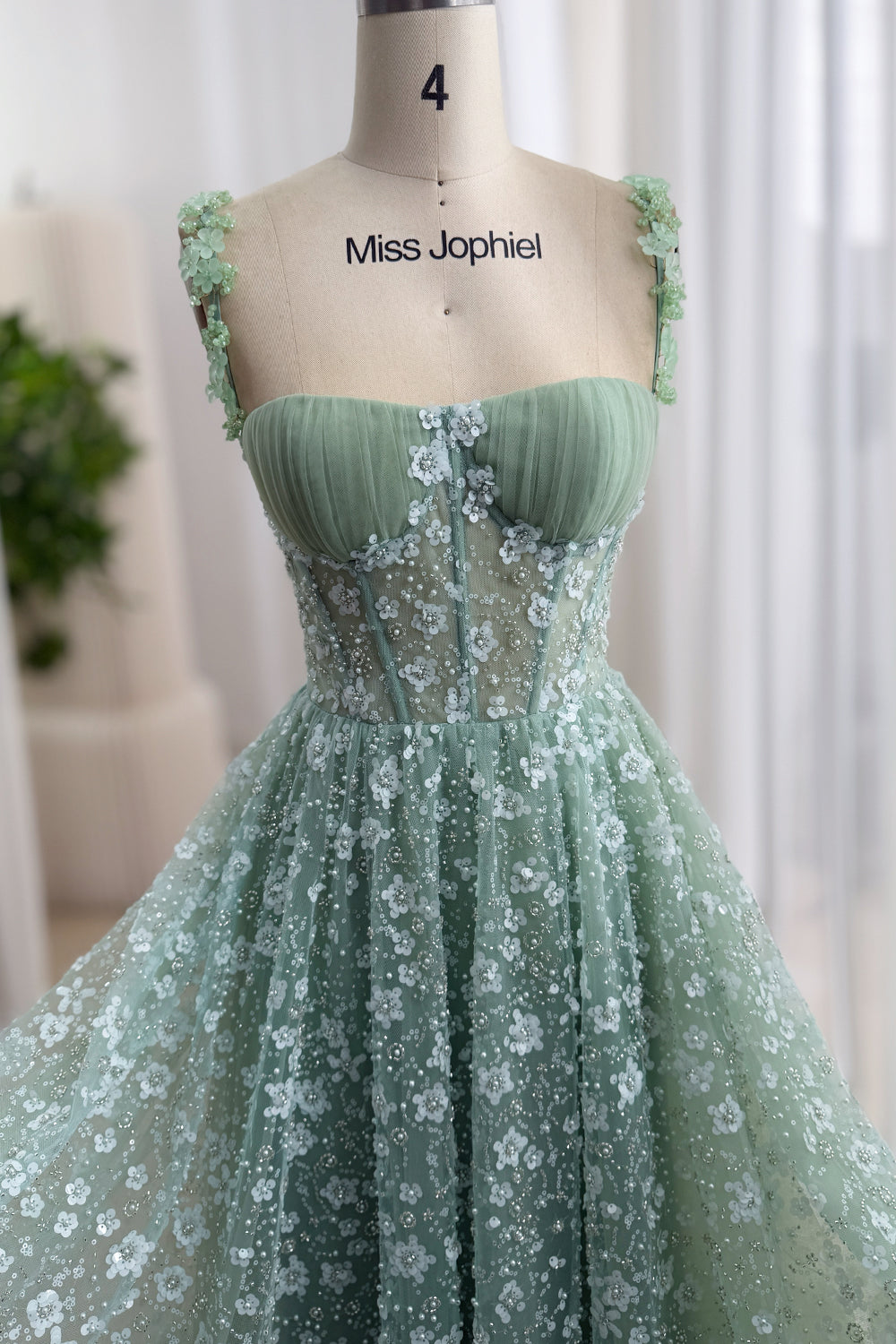 Front bodice view of a sage green floral sequin dress with a sweetheart neckline and flower-appliqué straps