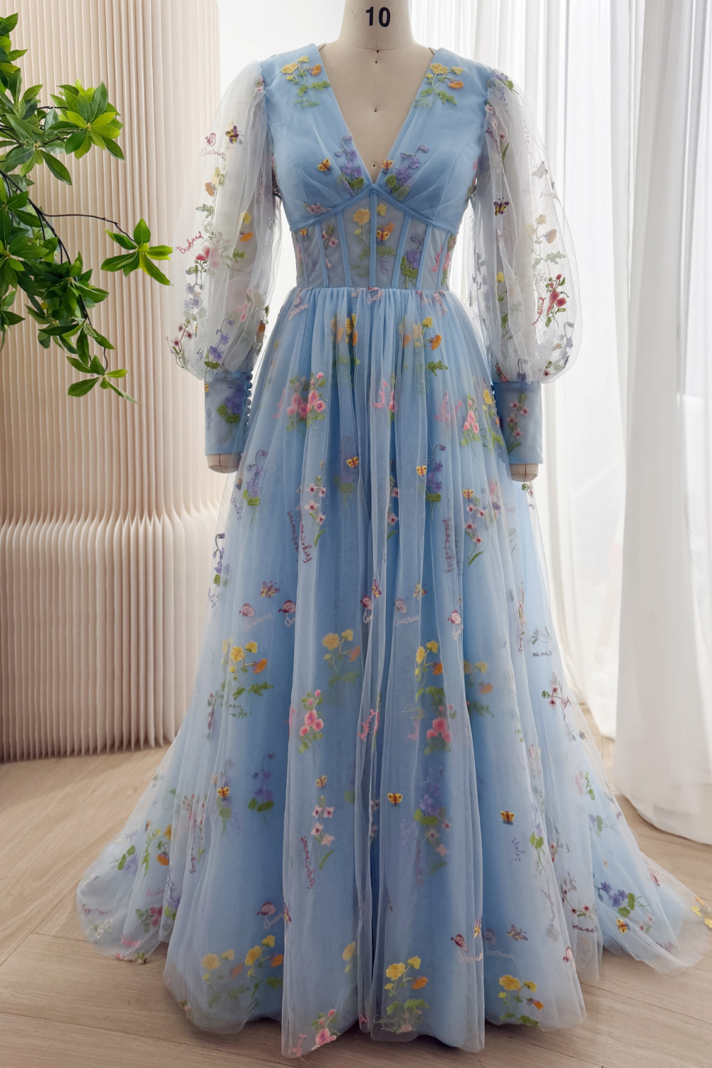 Sky blue floral embroidered tulle gown with V-neck, sheer long sleeves, full skirt, and train, front view