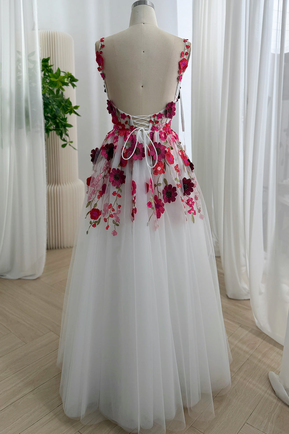 Back view of white floor-length floral embroidered tulle A-line dress with lace-up closure