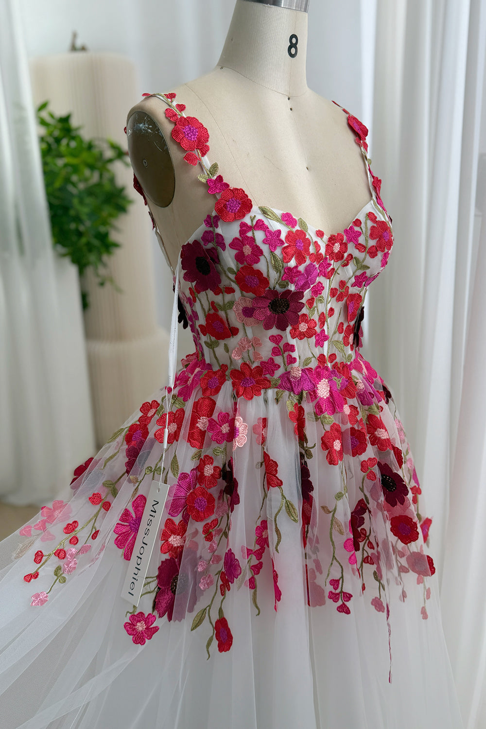 Side view of white floral embroidered tulle dress with fitted bodice and flowing A-line skirt