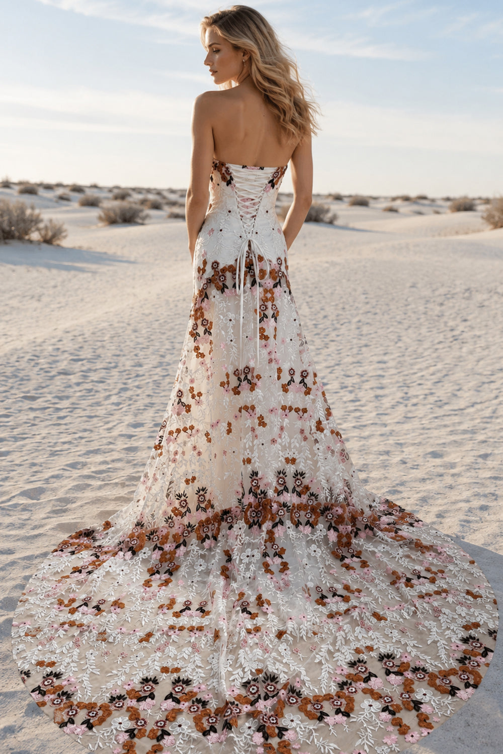 Model back view of the white embroidered wedding dress with lace-up closure and long floral train
